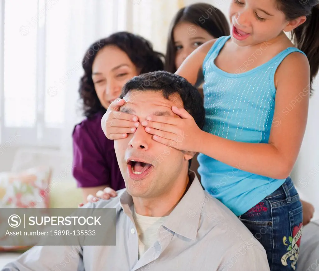 Daughter covering surprised father´s eyes