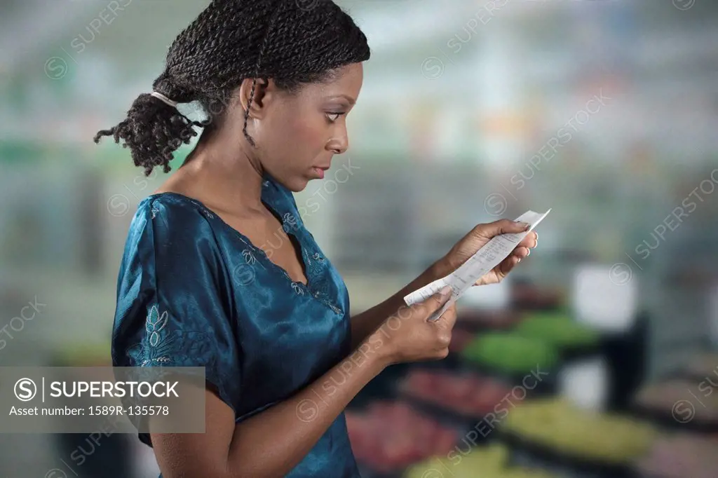 Black woman looking at grocery shopping list