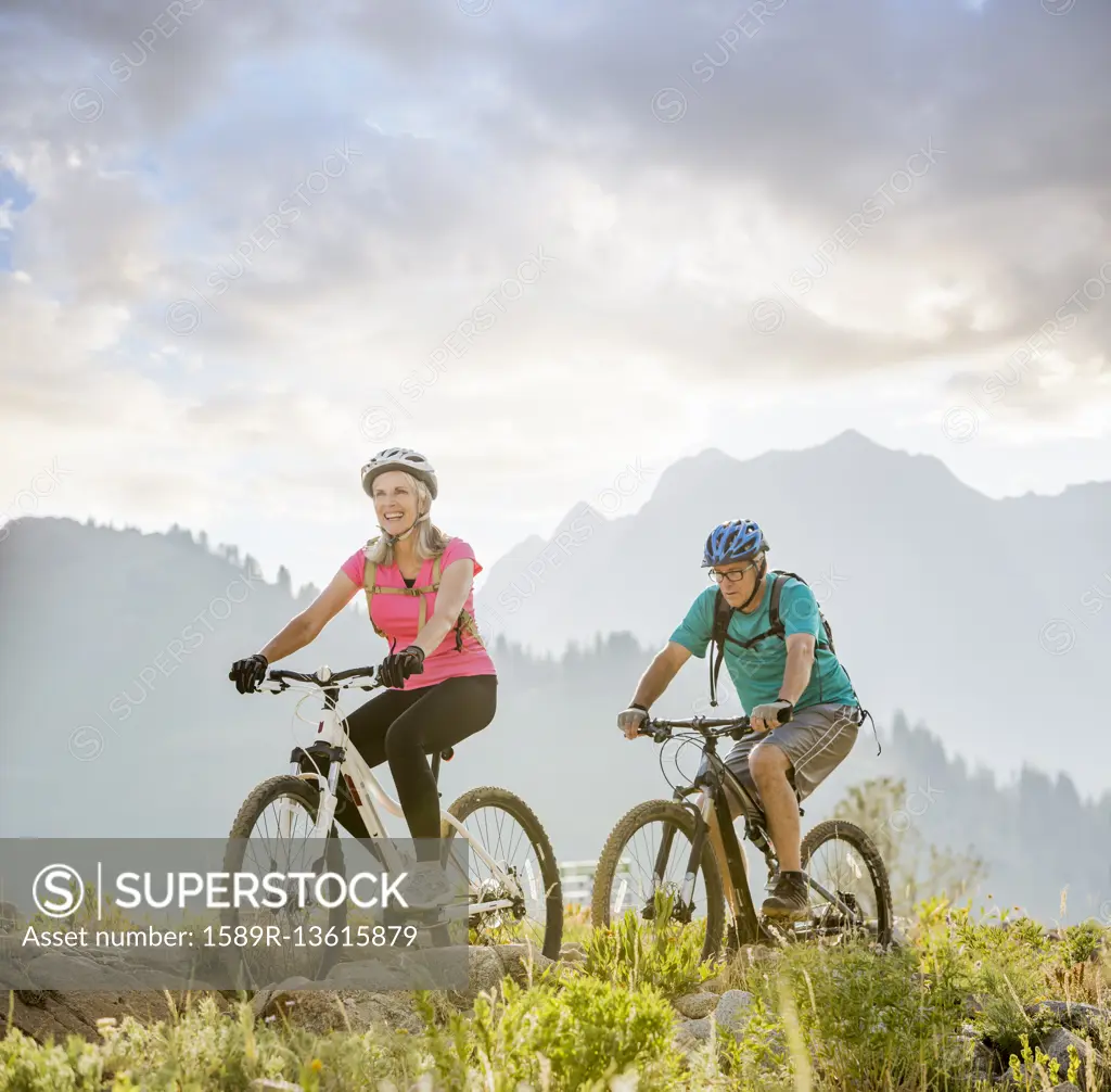 Caucasian couple riding mountain bikes