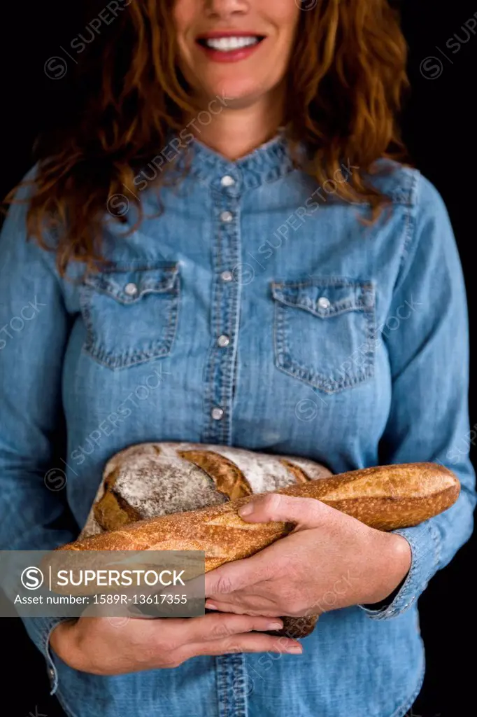 Smiling Caucasian woman holding bread