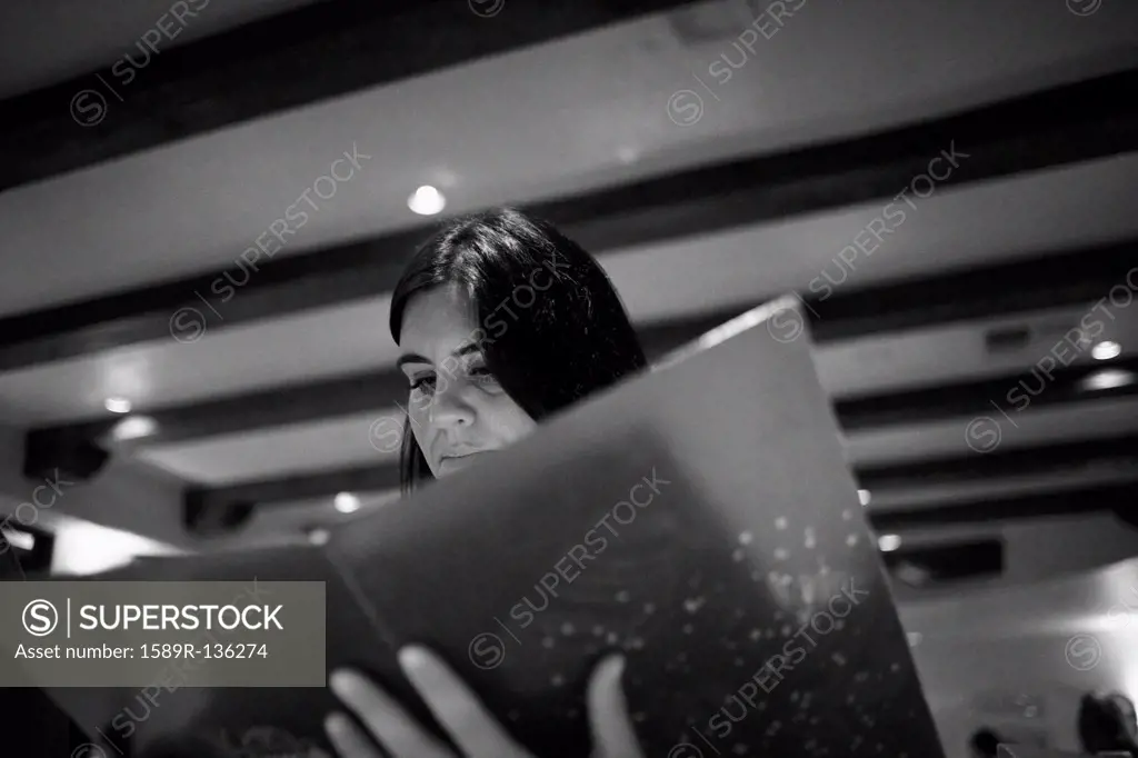 Caucasian woman reading menu in restaurant