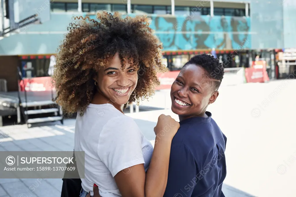 Portrait of smiling Black women hugging in city