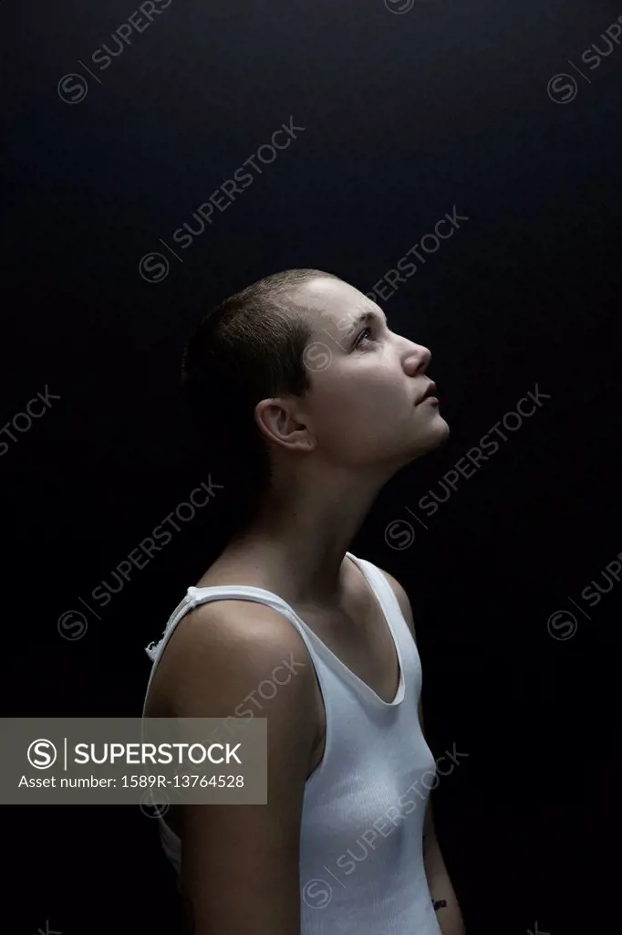 Caucasian woman with shaved-head looking up