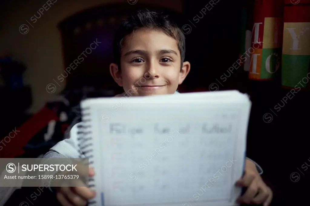 Proud Hispanic boy practicing writing alphabet
