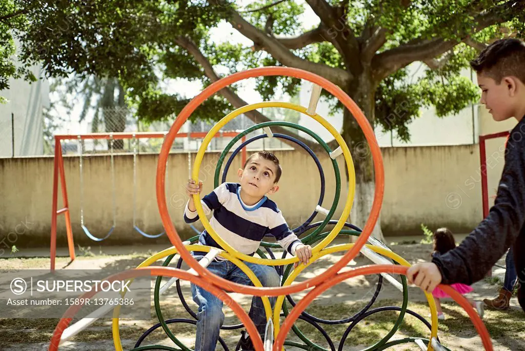 Hispanic boys climbing on structure at playground