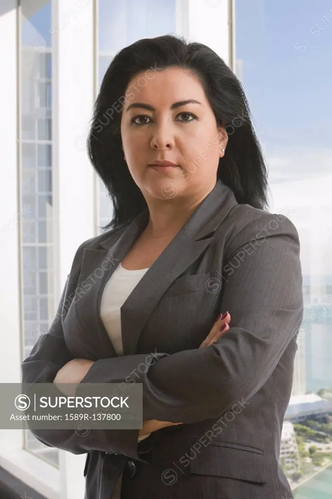 Hispanic businesswoman with arms crossed