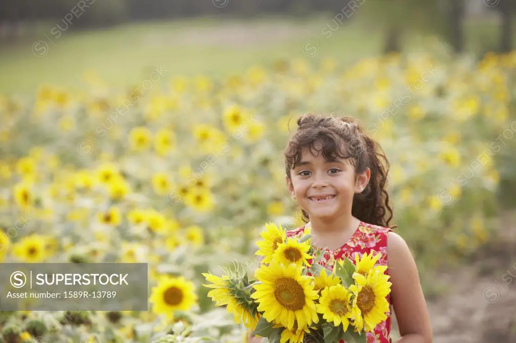 Young girl holding sunflowers