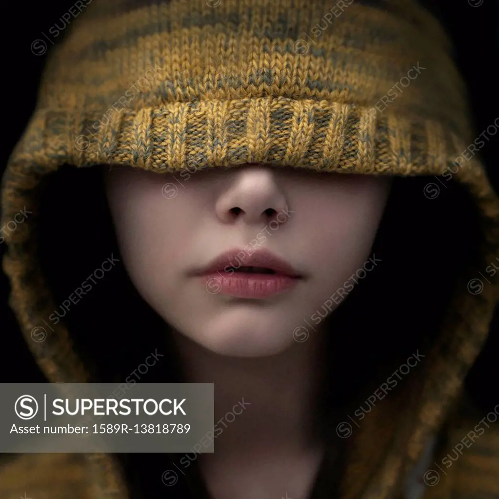 Portrait of Caucasian girl covering eyes with hood