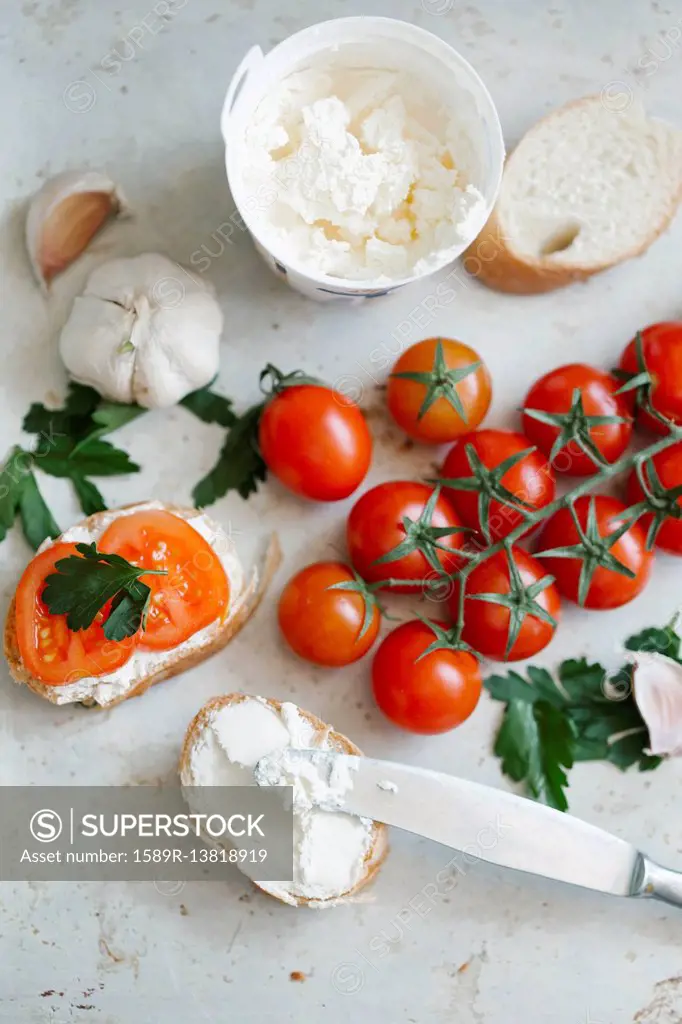 Tomatoes on vine near cream cheese and bread