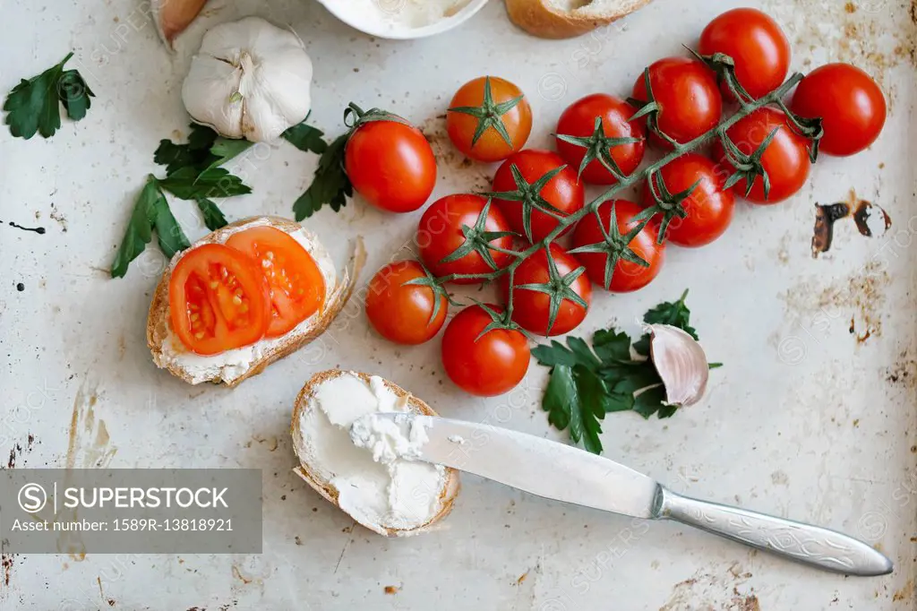 Tomatoes on vine near cream cheese and bread