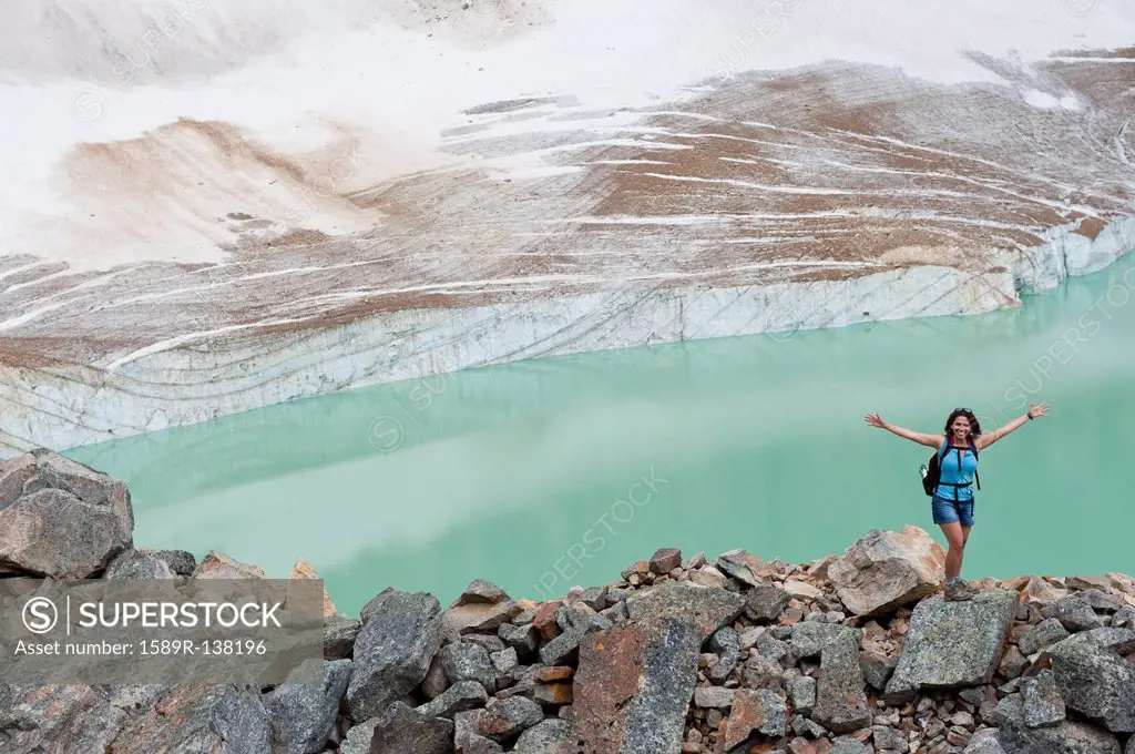 Hispanic woman hiking hear glacial lake