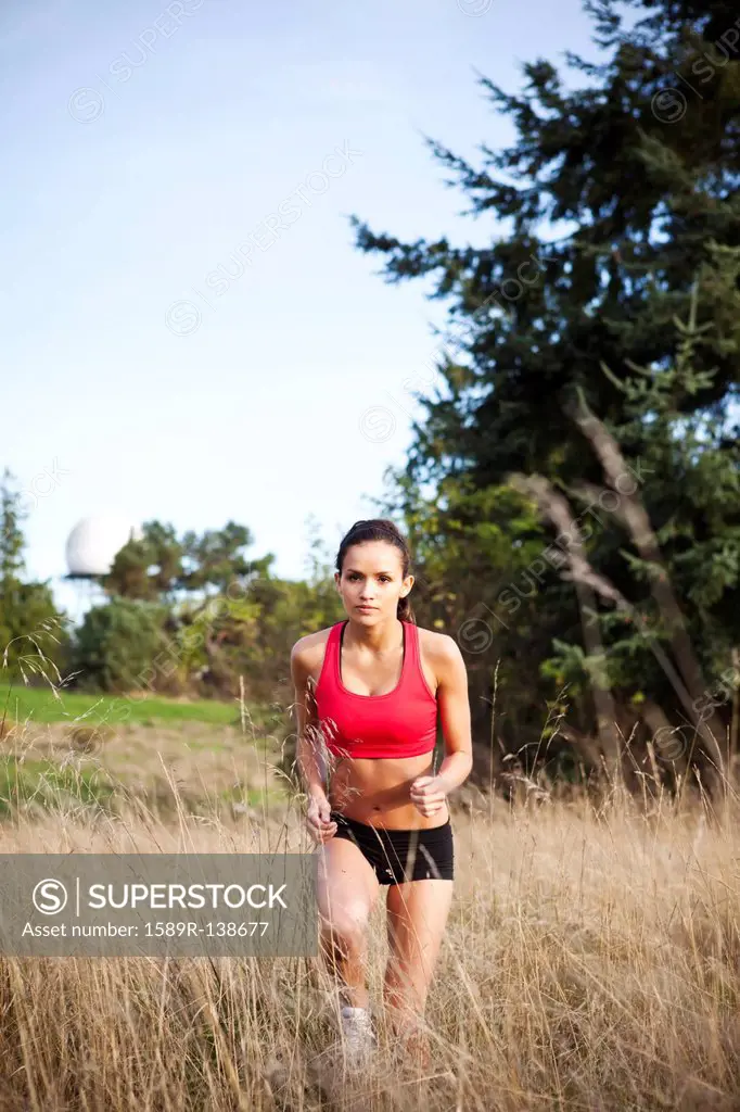 Mixed race jogger running through field