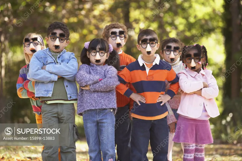 Portrait of group of children wearing funny nose and glasses
