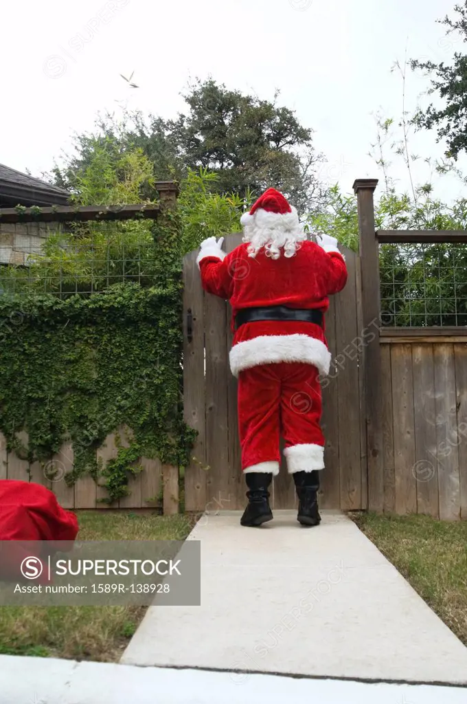 Santa peering over fence gate