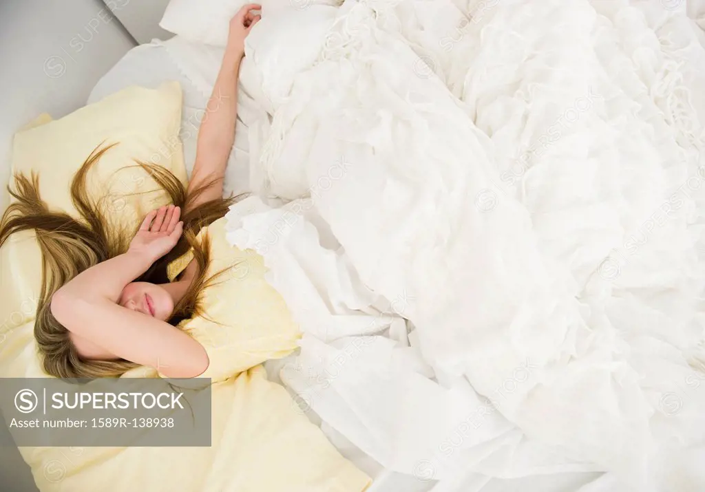Caucasian teenage girl sleeping in bed