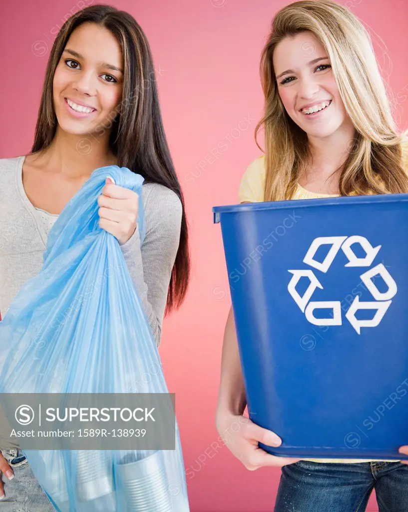 Teenage girls carrying recycling