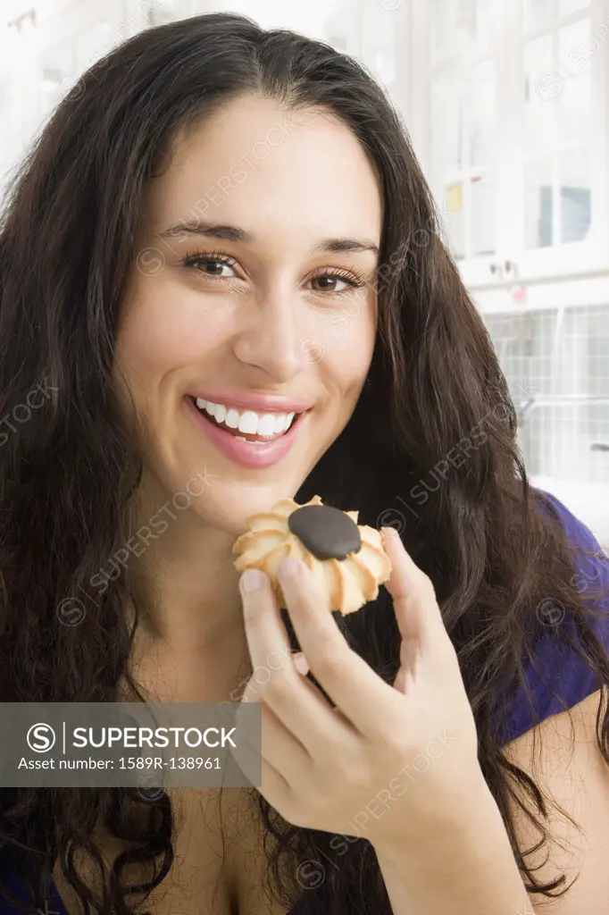 Mixed race woman eating a cookie