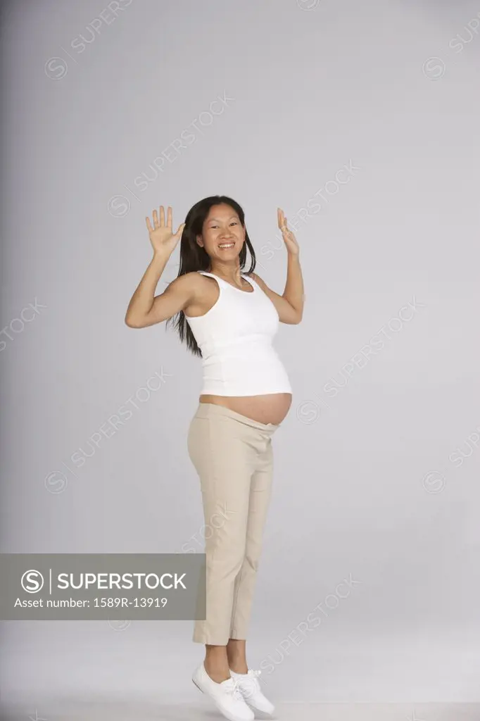 Portrait of pregnant woman jumping