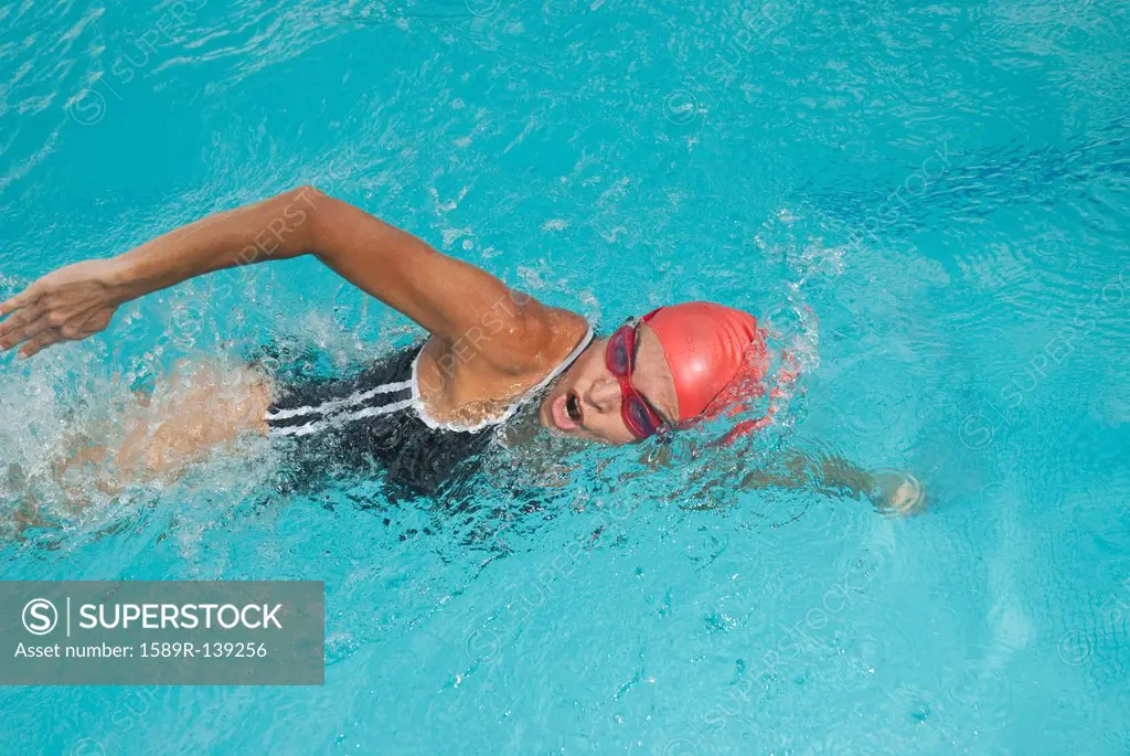 Hispanic woman swimming in swimming pool