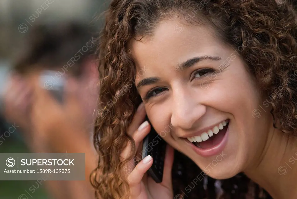 Smiling Hispanic woman talking on cell phone