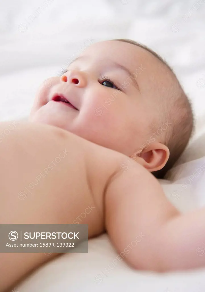 Mixed race baby laying on bed