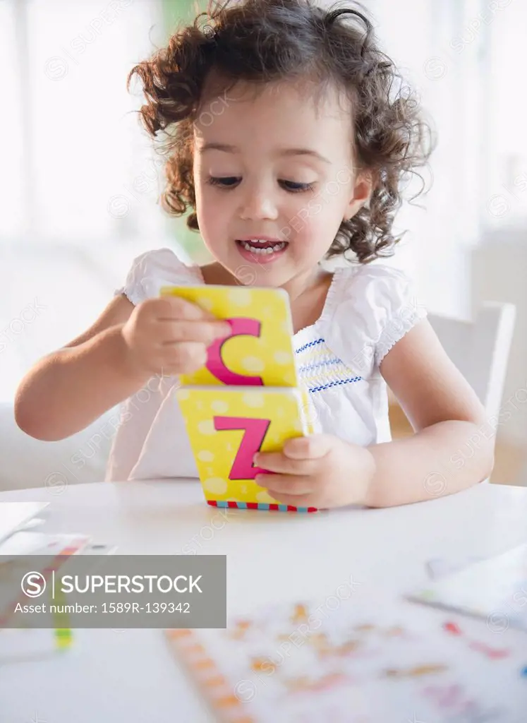 Mixed race girl playing with alphabet cards