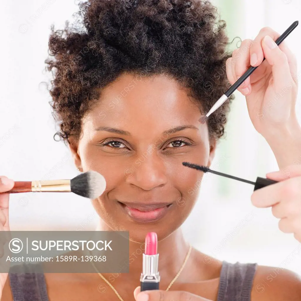 People putting makeup on Black woman