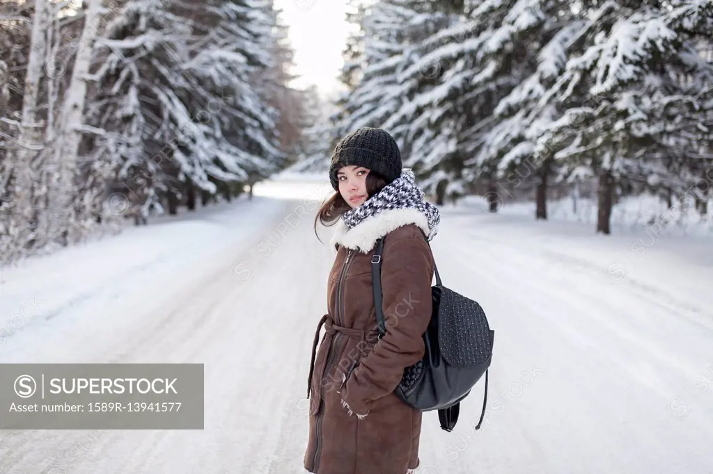 Asian woman carrying backpack on snowy road