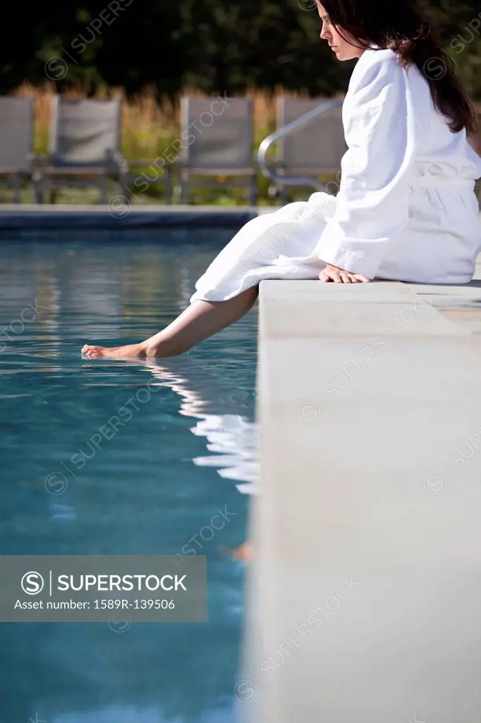 Woman soaking feet in swimming pool