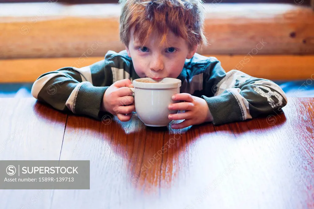 Caucasian boy drinking hot chocolate