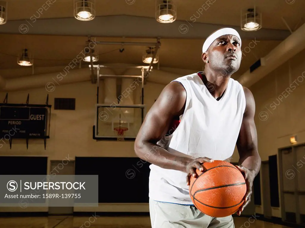 Black man shooting basketball on basketball court