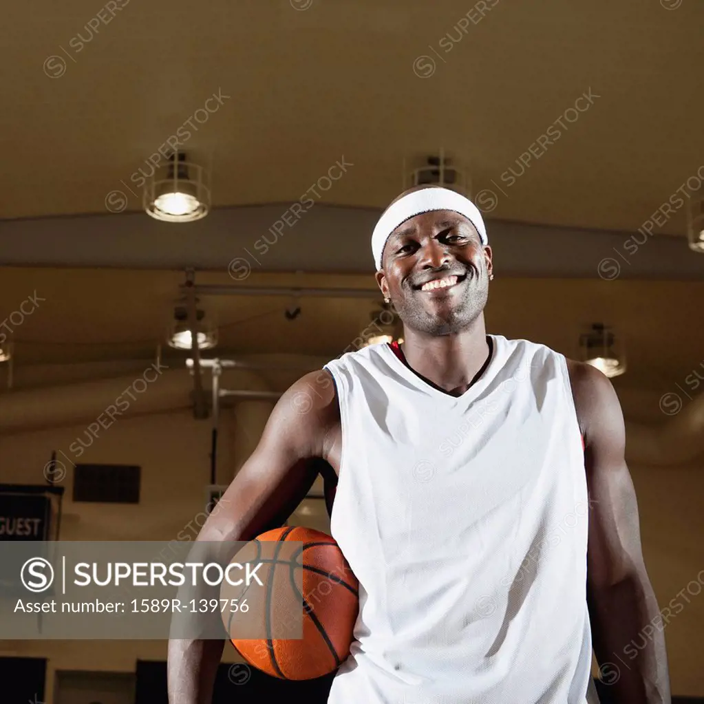Black man holding basketball on basketball court