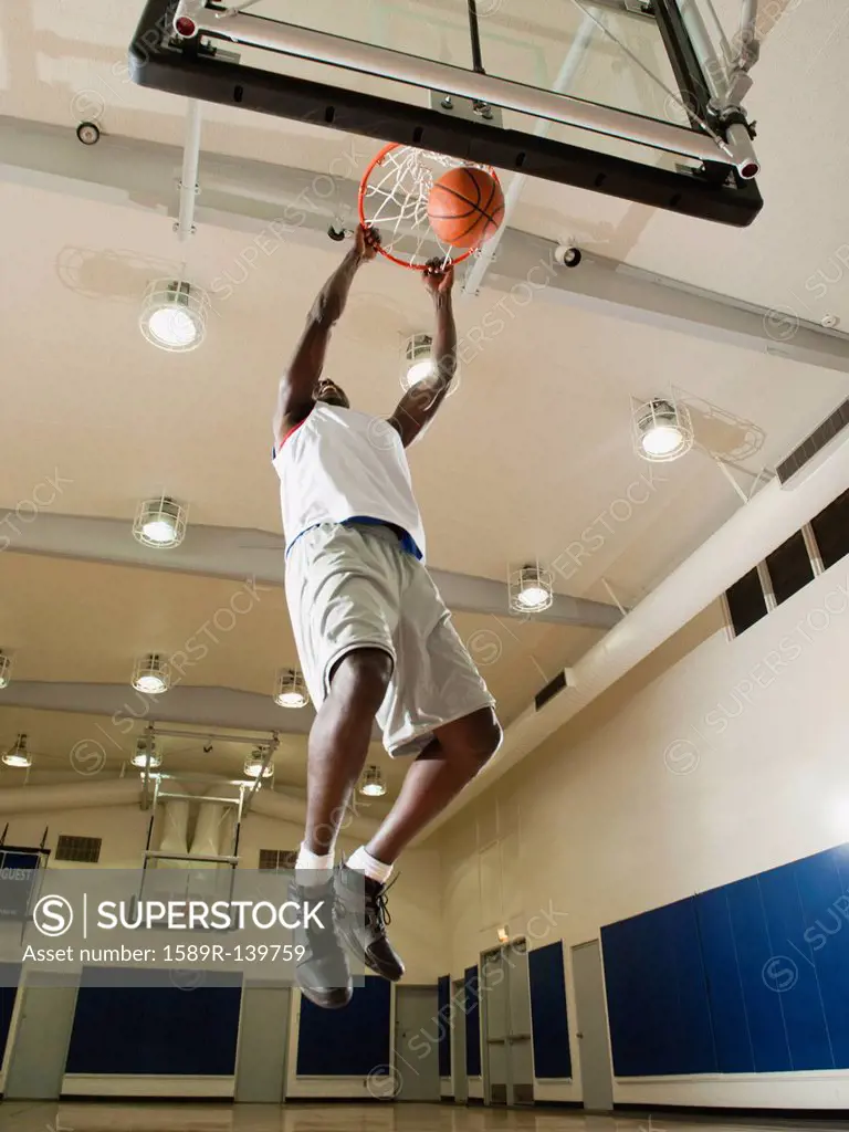 Black man shooting baskets on basketball court