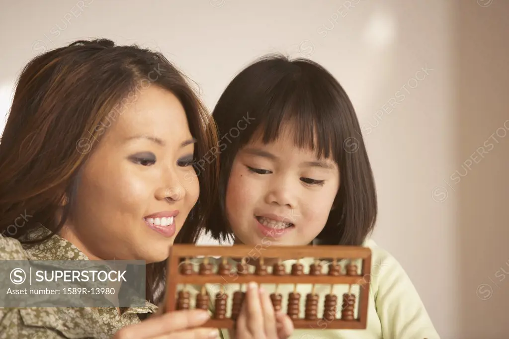 Mother and daughter using an abacus together
