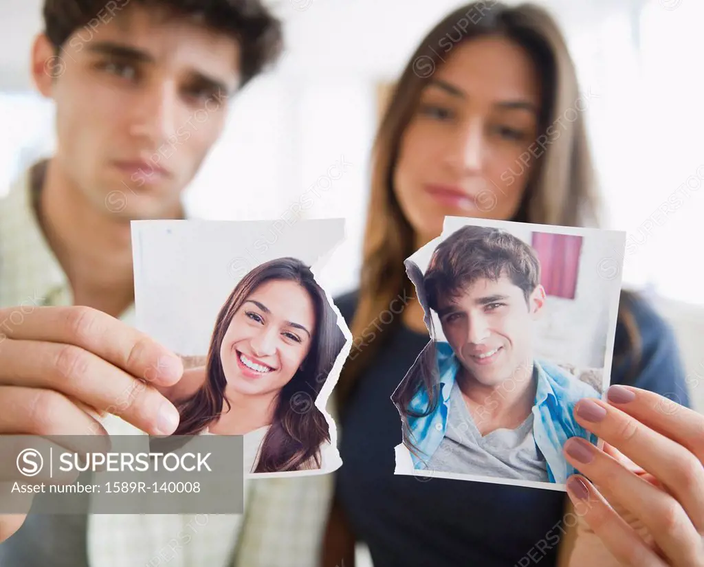 Couple holding torn photograph