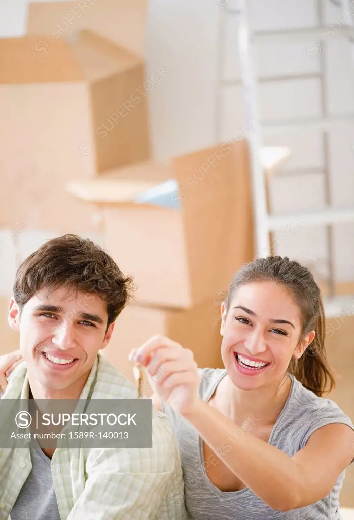 Excited couple holding keys to new home