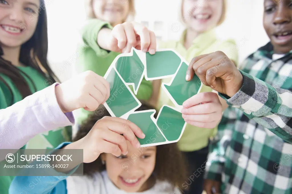 Children holding green recycling symbol