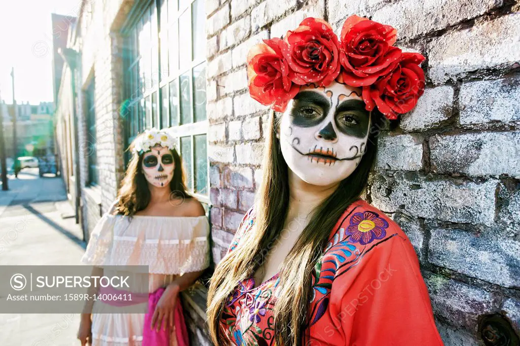 Women on sidewalk wearing skull face paint