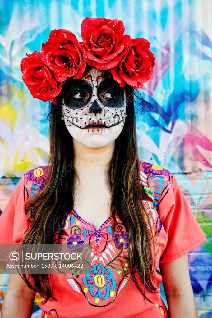 Hispanic woman wearing skull face paint