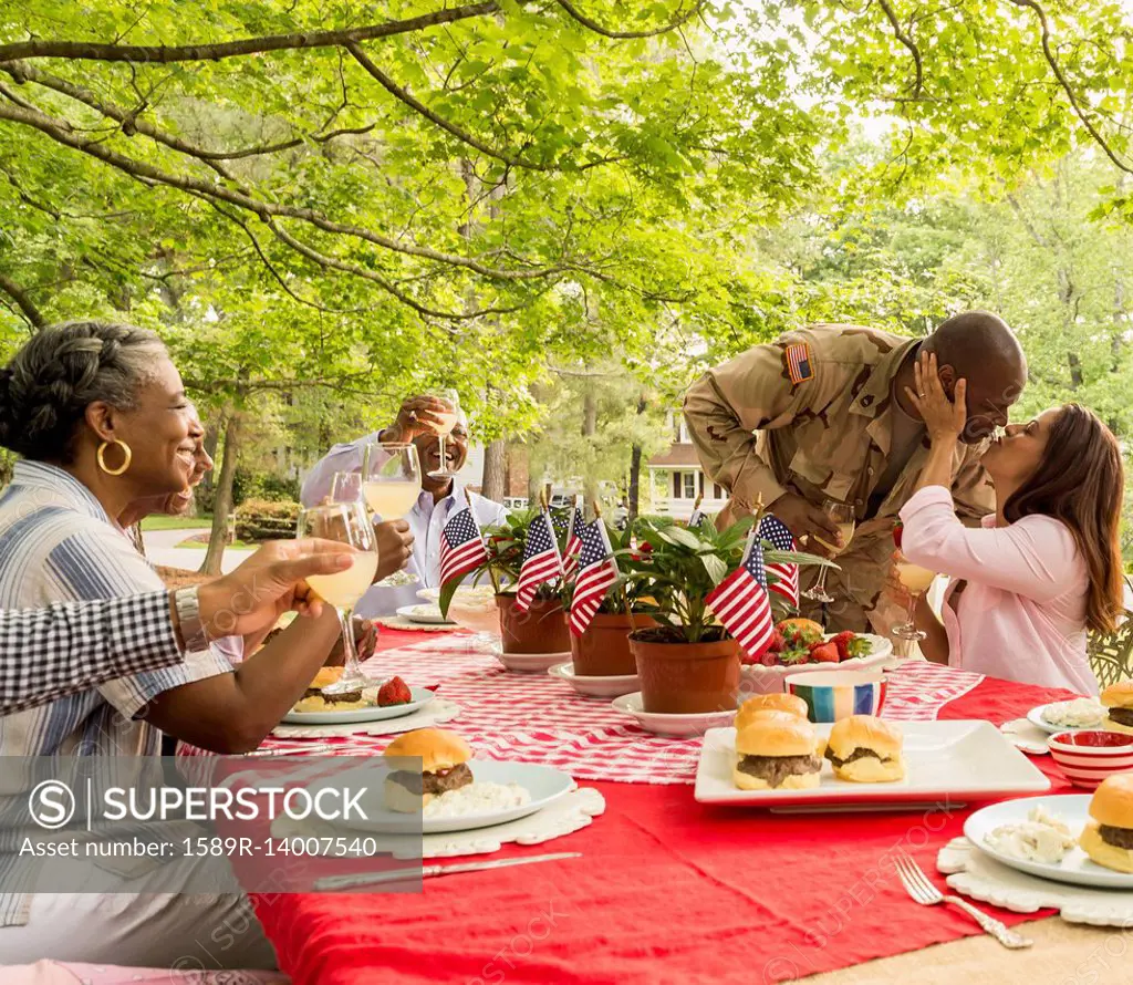 Soldier man kissing wife at picnic