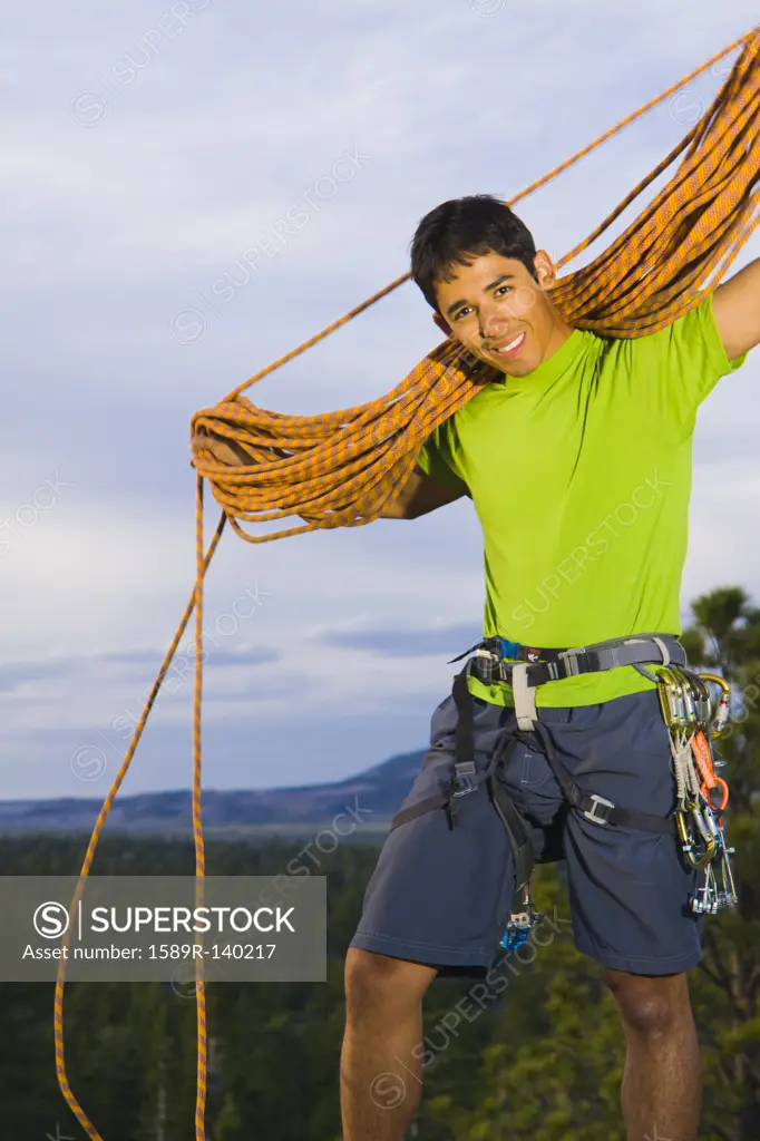 Hispanic man preparing for rock climbing