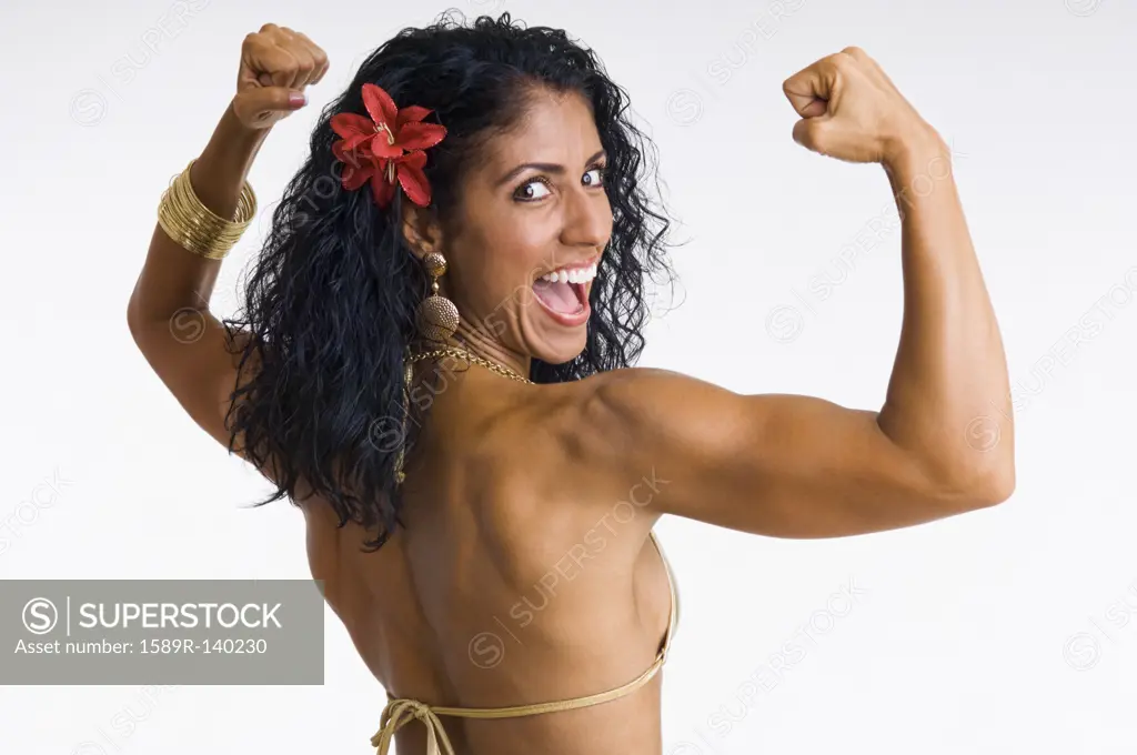 Mixed race woman body builder flexing muscles