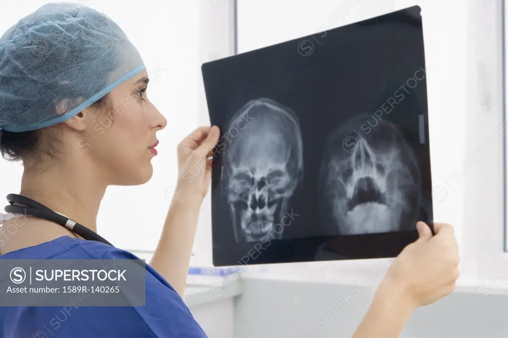 Mixed race surgeon reviewing x_rays