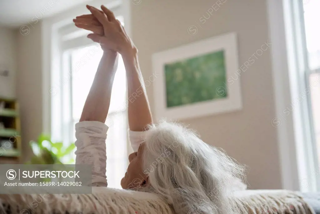 Older woman stretching with arms raised