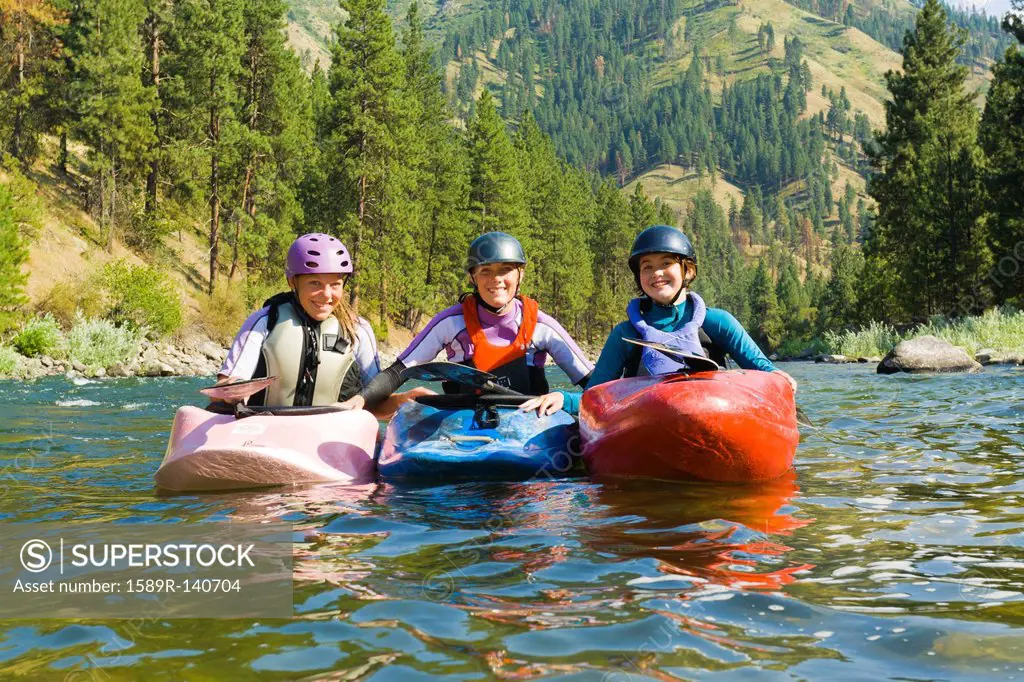Caucasian girls kayaking in river