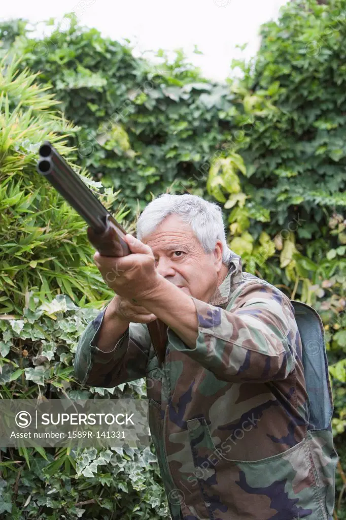 Senior Chilean man pointing shotgun