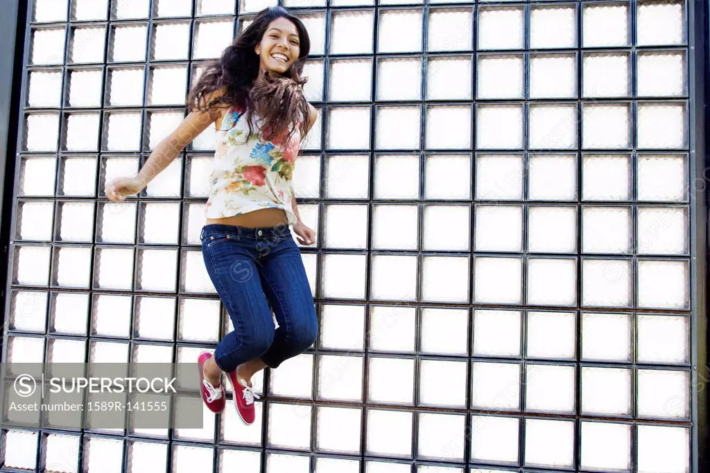 Hispanic teenager jumping in air