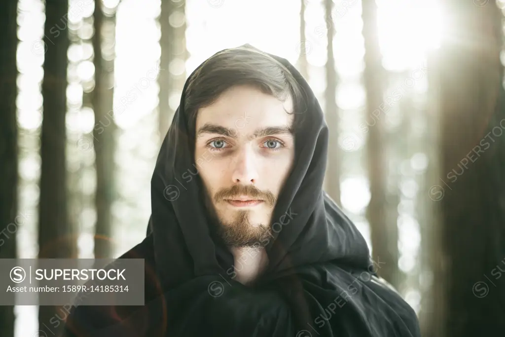 Caucasian man with beard wearing robe in forest