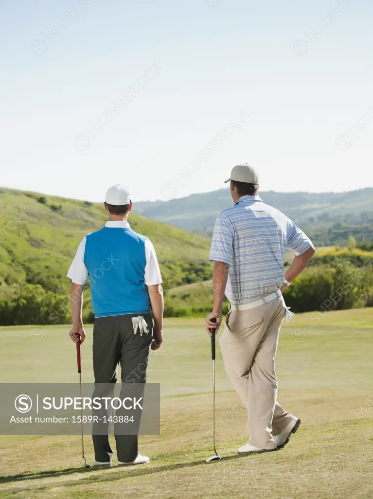 Caucasian men playing golf together on golf course