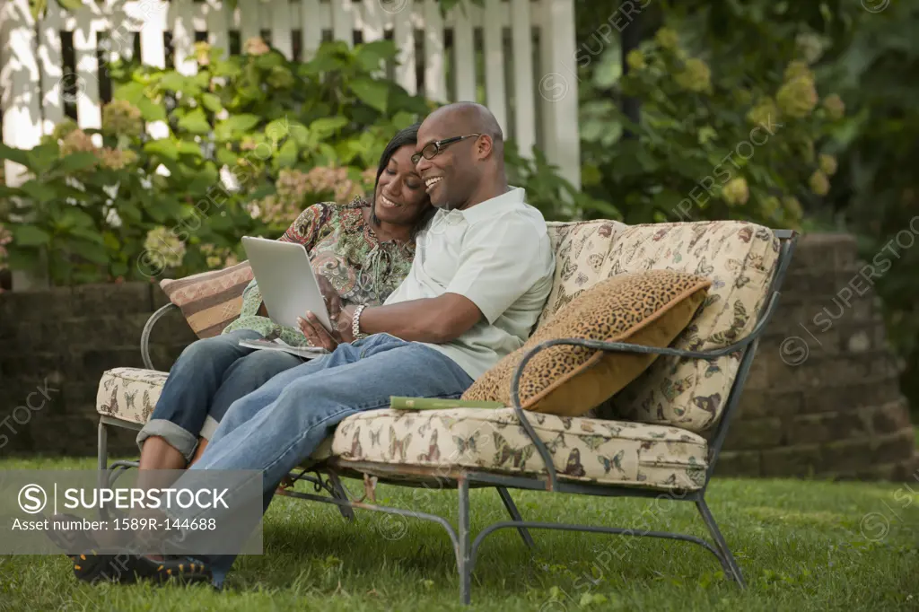 African American couple using digital tablet outdoors